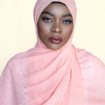 a lady is wearing orange diamond chiffon hijab